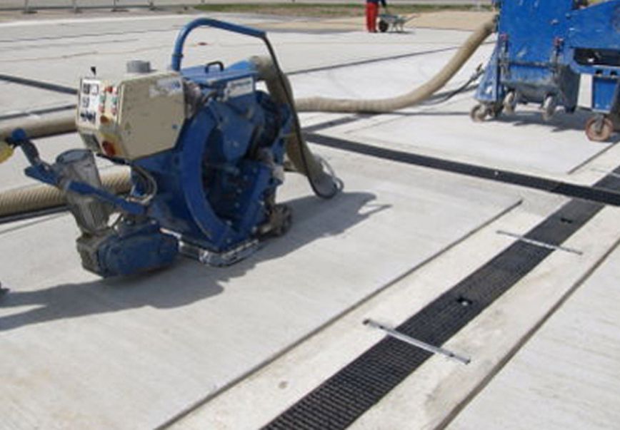Bilder des Kugelstrahlverfahren auf Asphalt mit blauen Maschinen