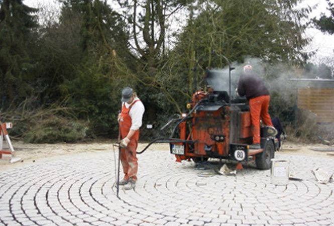 Employees laying the paving with machines in the background