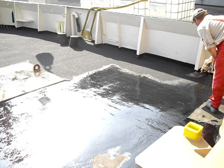 Ein Mitarbeiter in Arbeitskleidung bei der Ausführung des neuen Schiffsdecks