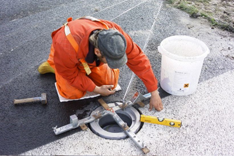 An employee in work clothes installing an underfloor fire